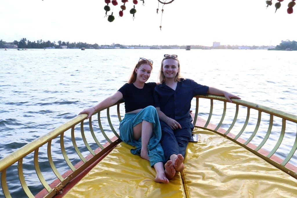 Couple relaxing together on a shikara boat deck under the twilight evening sky on Vembanad Lake